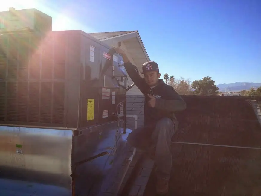 HVAC technician performing Air Duct Repair on a rooftop unit in DeBary